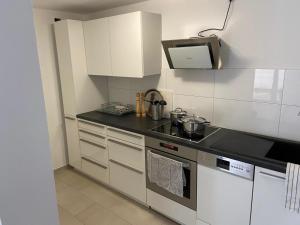 a kitchen with white cabinets and a stove top oven at Großzügiges Apartment in Biberach an der Riss in Biberach an der Riß