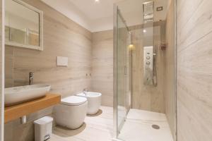 a bathroom with a toilet and a sink and a shower at Domu Ajaju Guest House in Villasimius