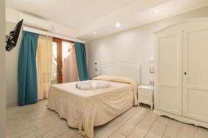 a bedroom with a bed with two towels on it at Domu Ajaju Guest House in Villasimius