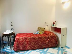 - une petite chambre avec un lit et une couverture rouge dans l'établissement Hotel Croce Di Amalfi, à Amalfi