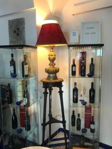 une lampe devant une vitrine avec bouteilles de vin dans l'établissement Hotel Croce Di Amalfi, à Amalfi