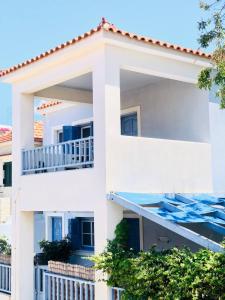 a white apartment building with a balcony at Blue Seaside House with Terrace in Skala Eresou