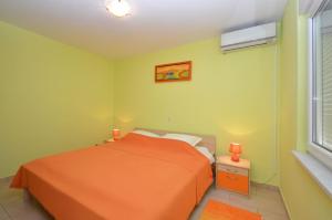 um quarto com uma cama laranja e uma janela em Apartment in Karbuni with sea view, terrace, air conditioning, W-LAN 3609-2 em Blato