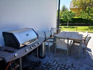 a grill and a table with chairs and a table and a table and chairs at No.44 in Balatonfüred