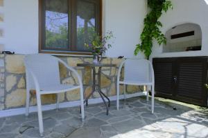 zwei weiße Stühle und ein Tisch auf einer Terrasse in der Unterkunft Alekas Studios in Therma + 95 Fotos