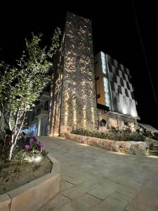 un edificio illuminato di notte di Hotel Qeparo a Qeparo