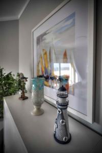 a shelf with vases and a painting on a wall at Apartamentos Belo Horizonte in Portimão