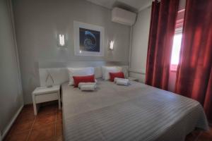 a bedroom with a large bed with red pillows at Apartamentos Belo Horizonte in Portimão