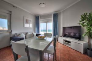 a living room with a dining table and a television at Apartamentos Belo Horizonte in Portimão