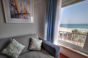 a living room with a couch and a large window at Apartamentos Belo Horizonte in Portimão