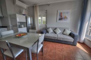 a kitchen and living room with a table and a couch at Apartamentos Belo Horizonte in Portimão