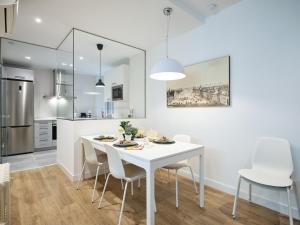 cocina y comedor con mesa blanca y sillas en My City Home - Fantastic apartament at Moncloa for students, en Madrid