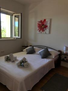 Un dormitorio con una gran cama blanca con flores. en Apartments Mira, en Trogir