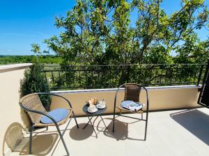 un patio con 2 sedie e un tavolo sul balcone di BOUTIQUE ROOMS Mare Fabulas a Rovigno (Rovinj)