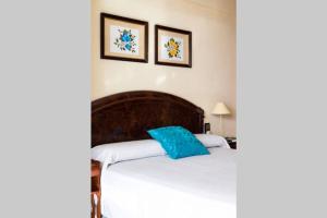 sypialnia z łóżkiem z niebieską poduszką w obiekcie Seafront Luxury Levante Beach / Primera línea playa levante w mieście Benidorm