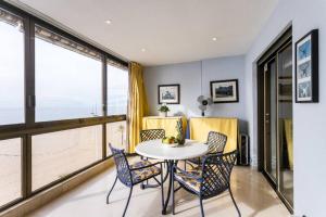 jadalnia ze stołem, krzesłami i oknami w obiekcie Seafront Luxury Levante Beach / Primera línea playa levante w mieście Benidorm