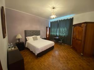 a bedroom with a bed and a table and a chair at Alma mía - Hospedaje Cholula in Cholula