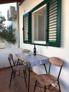 una mesa y sillas en un patio con ventana en Apartments Mira, en Trogir