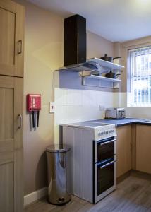 una pequeña cocina con fogones y fregadero en Abercorn Place Entire House 4 Bedrooms en Scunthorpe