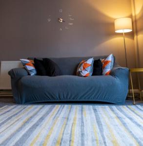 um sofá azul com almofadas numa sala de estar em Abercorn Place Entire House 4 Bedrooms em Scunthorpe