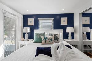 um quarto com uma grande cama branca com paredes azuis em The Bahama Breeze at the Anchorage em Fort Myers Beach