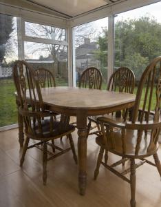 a wooden table and chairs in front of a window at Abercorn Place Entire House 4 Bedrooms in Scunthorpe
