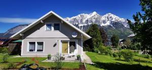 una casa blanca con montañas al fondo en Grimming View, en Niederöblarn
