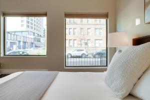 sypialnia z łóżkiem i dużym oknem w obiekcie Sojourn at DuPont Place w Waszyngtonie