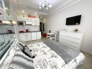 a bedroom with a bed and a tv on a wall at Apartment Studio PARIS 51 in Irpin