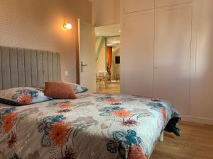 a bedroom with a bed with a floral bedspread at Entre Cher et Loire in Pontlevoy