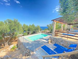 a swimming pool with blue chairs next to a house at Villa Aurora in Corsano