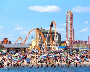 a crowd of people on a beach with roller coaster at Classical American House 4 in Brooklyn