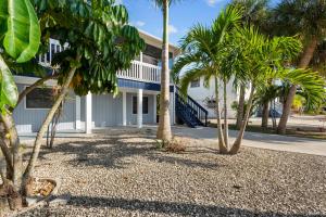 een wit gebouw met palmbomen ervoor bij The Pina Colada at the Anchorage in Fort Myers Beach