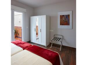 1 dormitorio con 1 cama y 1 silla en Apartamentos Caballerizas Granada con parking gratuito en pleno centro, en Granada