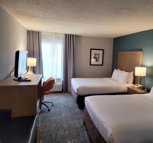 Comfort Inn & Suites Alexandria West tesisinde bir odada yatak veya yataklar