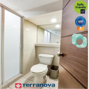 a bathroom with a toilet and a door with a mirror at Hotel Terranova in León