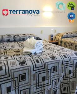 a hotel room with two beds with a white pillow on the bed at Hotel Terranova in León
