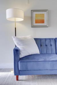 a blue couch in a living room with a lamp at Sojourn at DuPont Place in Washington, D.C.