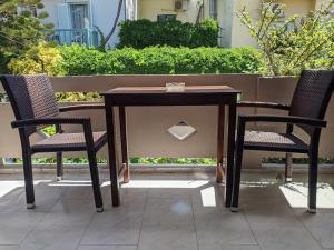 a wooden table and two chairs on a patio at Pension Irene in Sougia
