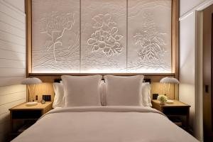 a bedroom with a large bed with white pillows at Four Seasons New Orleans in New Orleans