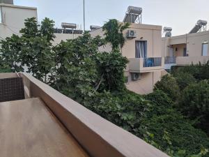 a balcony of a building with trees and bushes at Pension Irene in Sougia