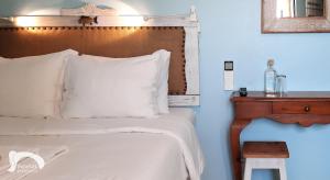 a bedroom with a bed with a wooden headboard and a table at Infante Guesthouse in Lagos