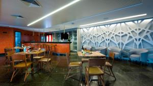 a restaurant with tables and chairs and a bar at Hotel Senac Ilha do Boi in Vitória