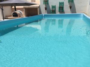 a large blue swimming pool with chairs and an umbrella at Casa El tio Daniel in Bargas