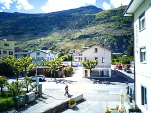 Eine Person, die auf einem Skateboard eine Straße hinunterreitet in der Unterkunft Hotel du Stand in Martigny-Ville