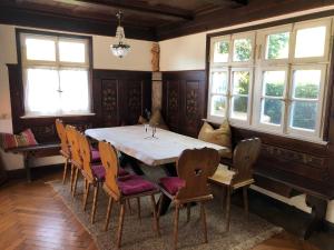 Schatzl Hütte في باد تولز: غرفة طعام مع طاولة وكراسي ونوافذ