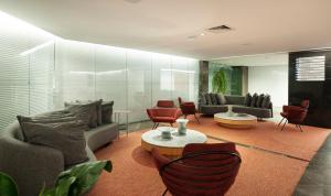 a living room with couches and tables and chairs at Hotel Senac Ilha do Boi in Vitória