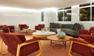 a living room with a couch and chairs and tables at Hotel Senac Ilha do Boi in Vitória