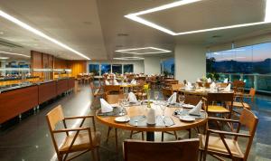 a restaurant with wooden tables and chairs with a view at Hotel Senac Ilha do Boi in Vitória
