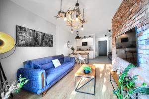 a living room with a blue couch and a brick wall at Apartament AP30 in Mielno